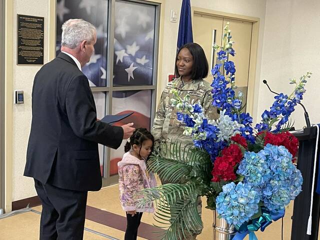 Ingutu Smith, with her daughter, Schuyler, 4, at her side, accepts LCCC’s first Veterans Day Scholarship from LCCC President Thomas Leary on Friday.
                                 Bill O’Boyle | Times Leader