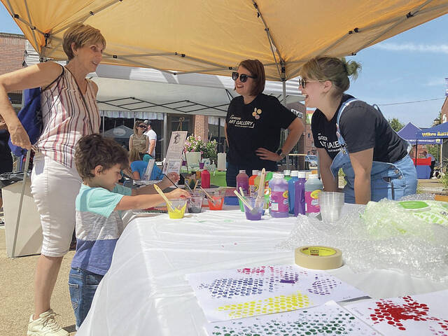 At the Sordoni Art Gallery table, Joshua Garibay paints his masterpiece while his grandmother Donna chats with the representatives from the gallery at a previous year’s Downtown Discoveries event.
                                 Times Leader File Photos